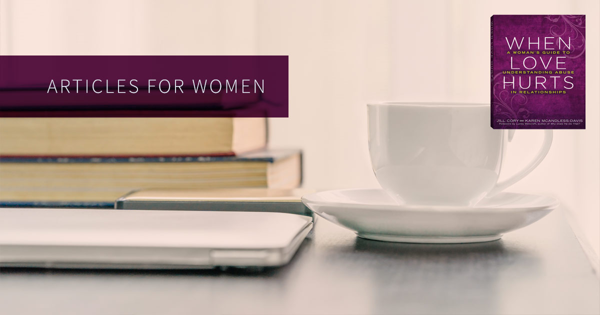 Articles for women, coffee cup beside a stack of books and a computer.