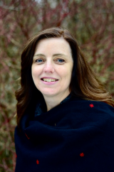 Karen McAndless-Davis stands outside in a dark blue coat, with her hair in the wind.