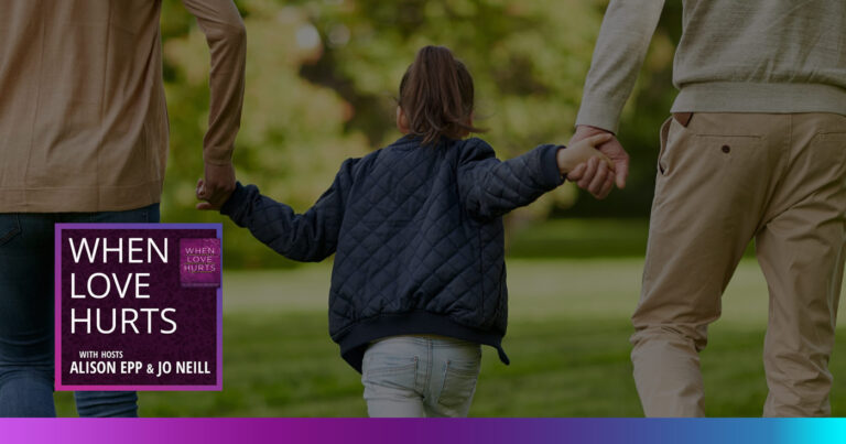 A man and woman hold a child's hand on both sides while walking away in the park.